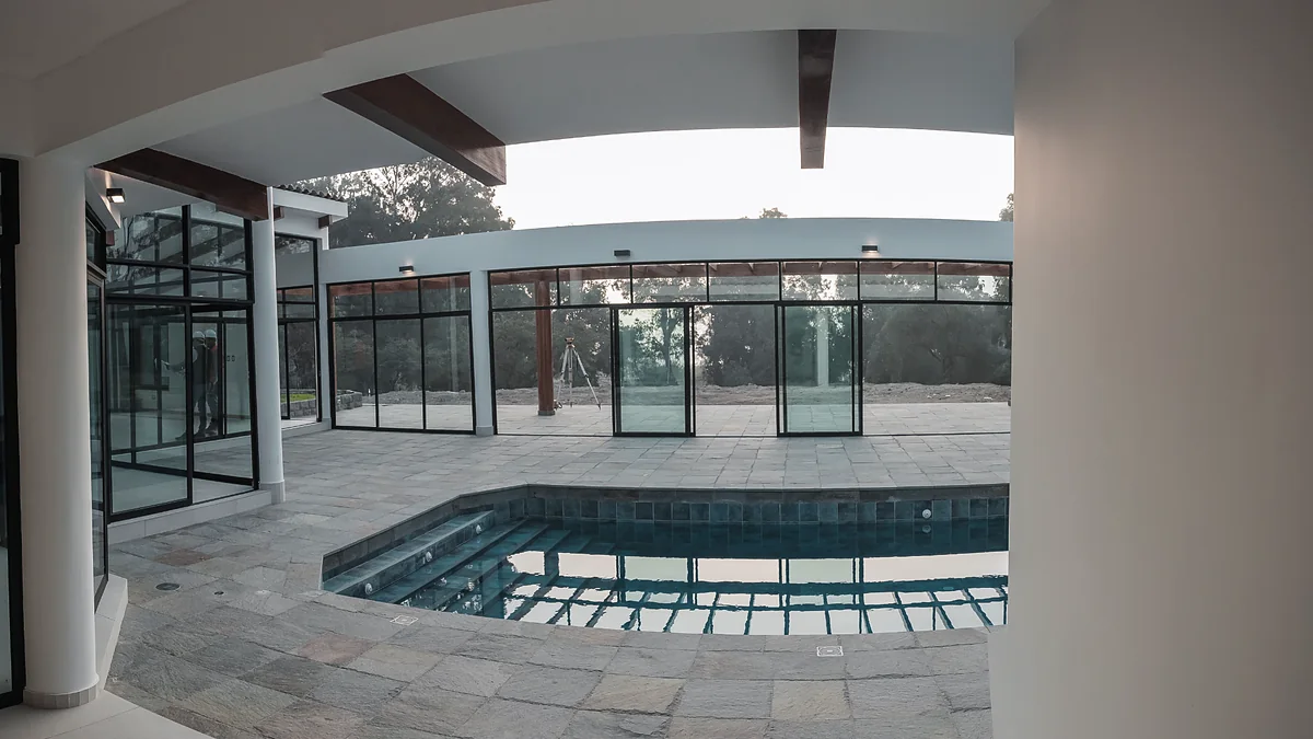 Piscina y mamparas de vidrio de la Vivienda Montaño en Chaclacayo