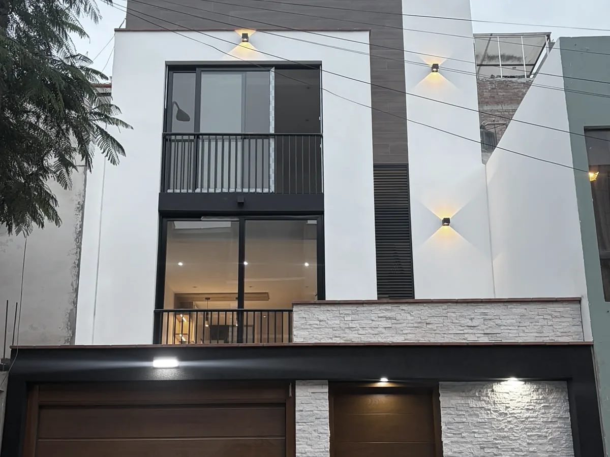 Fachada de edificio multifamiliar terminado con balcón y cochera