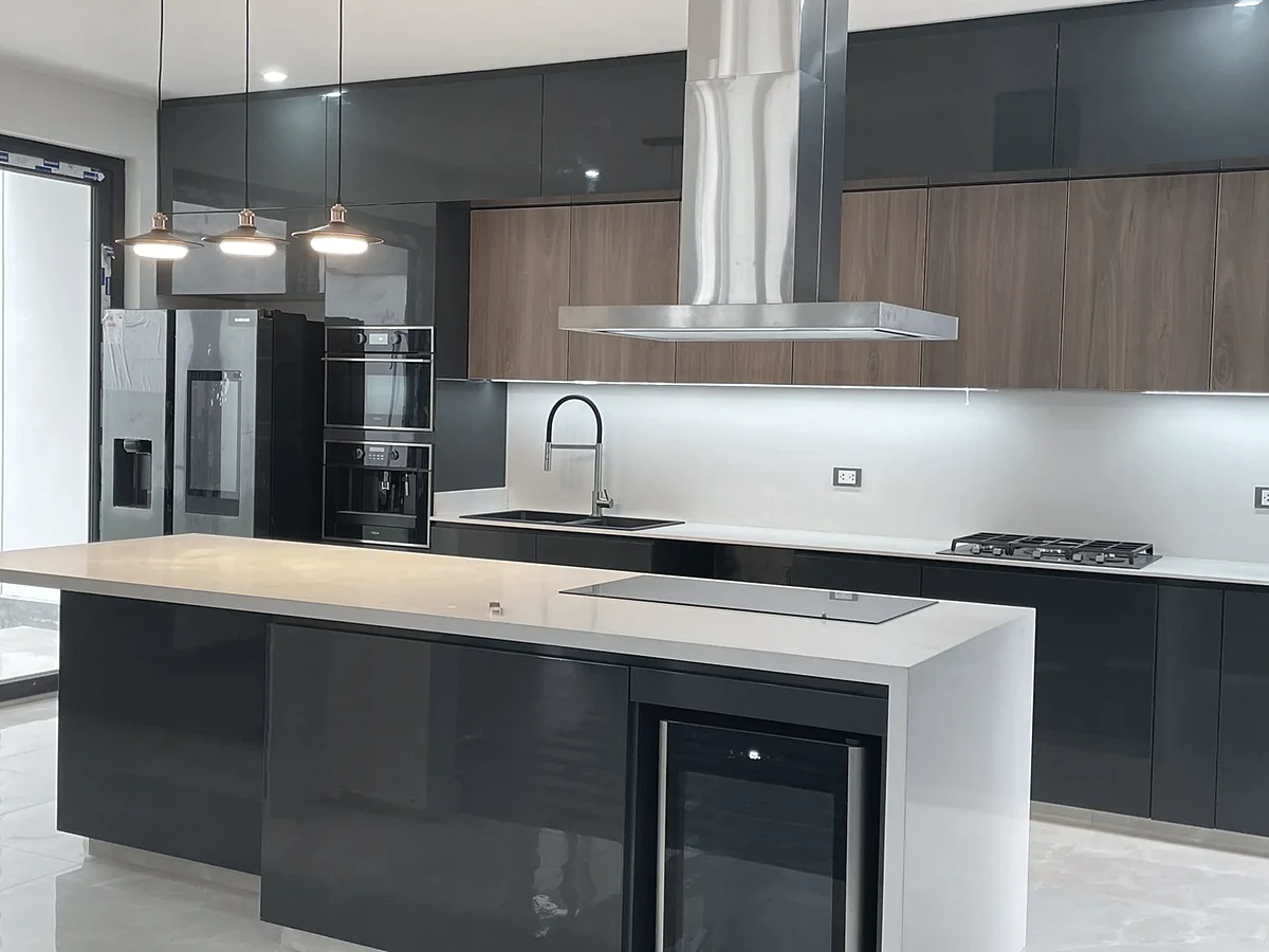 Cocina remodelada con isla, campana y acabados oscuros