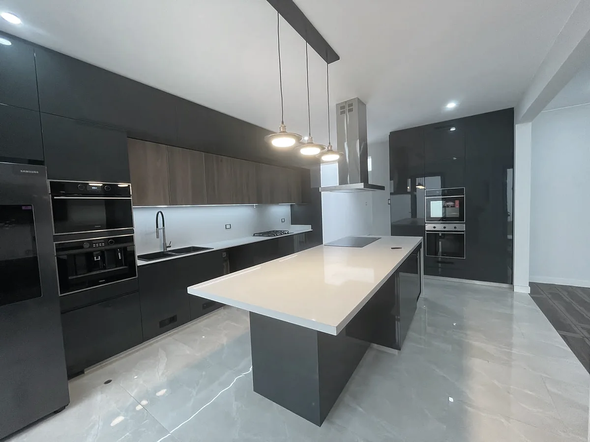 Cocina remodelada con isla y luminarias colgantes